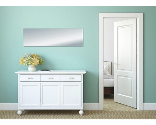 Pièce lumineuse avec commode, miroir et porte ouverte