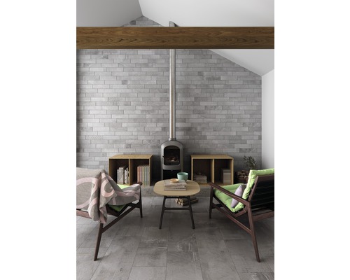 Salon avec cheminée en pierre, mur en briques et poutres en bois
