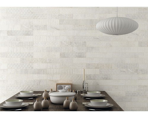 Décoration murale avec des carreaux clairs à motifs au-dessus d''une table à manger.