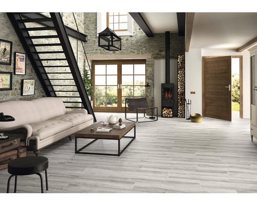 Salon avec canapé, cheminée, escalier et carrelage imitation bois