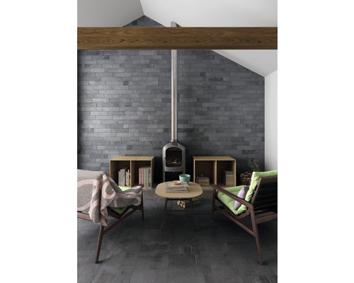 Salon avec cheminée, deux fauteuils, table basse, mur carrelé et sol carrelé