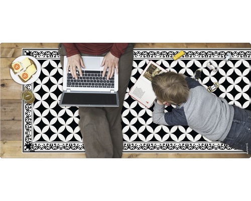 Person mit Laptop und Kind auf einer schwarzen und weißen Vinylmatte