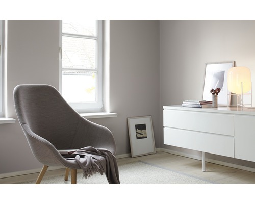 Helles Interieur mit Sessel, Kommode und Fenster für eine freundliche Raumatmosphäre.