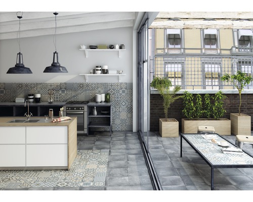 Helle Küche mit Kücheninsel, Fliesenboden, Küchentisch und Pflanzen auf der Terrasse