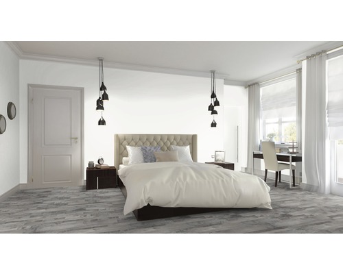 Helles Schlafzimmer mit Bett, Nachttischen, Hängelampen und Schreibtisch am Fenster.