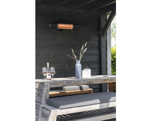 Terrassenszene mit Heizstrahler, Holztisch, Bänken, Dekoration und Getränken