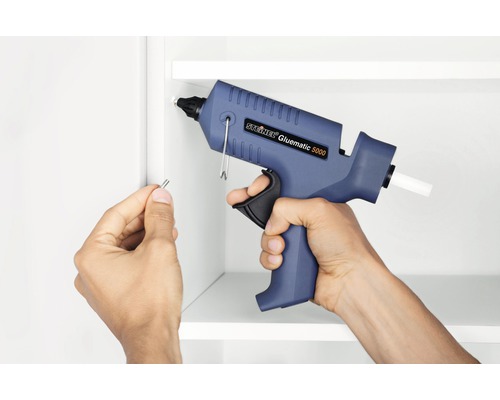 Anwendung einer Steinel Gluematic 5000 Heißklebepistole zum Anbringen eines Stifts an einem weißen Regal