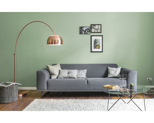 Wohnzimmer mit grauem Sofa, Bogenlampe, Couchtisch und Dekoration