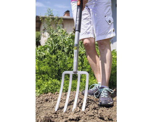 Person mit einer Grabgabel im Garten.