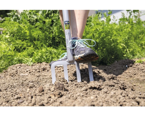 Person verwendet eine Grabegabel im Garten.