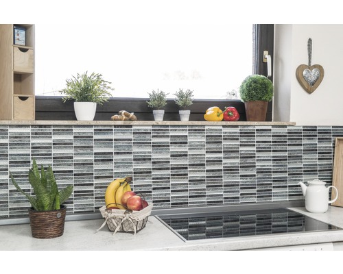 Scène de cuisine avec mur en carreaux de mosaïque, rebord de fenêtre avec décoration et panier de fruits