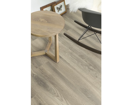 Pièce lumineuse avec plancher en bois, table ronde et fauteuil à bascule