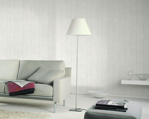 Wohnzimmer mit Sofa, Stehlampe und dekorativer Wandgestaltung für ein helles Ambiente.