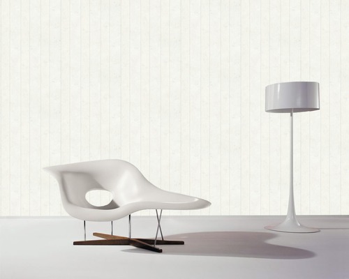 Moderne Inneneinrichtung mit einem Sessel und einer Stehlampe vor einer Tapete mit Holzoptik