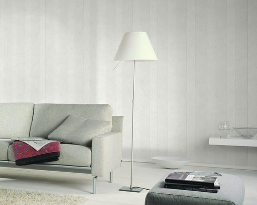 Wohnzimmer mit Sofa, Stehlampe und dekorativer Wandgestaltung für ein helles und modernes Ambiente.