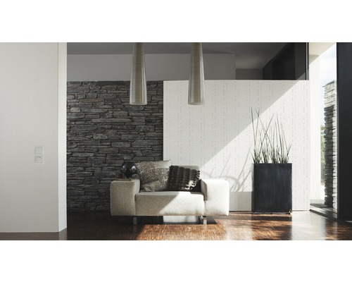 Modernes Wohnzimmer mit Sessel, Steinwand und Zimmerpflanze