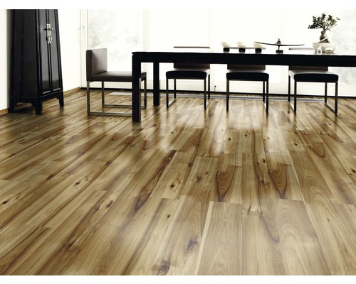 Helles Zimmer mit Holzboden, Tisch und Stühlen.