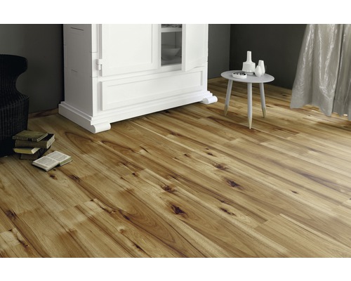 Verlegtes Laminat in einem Wohnraum mit Schrank und Tisch.