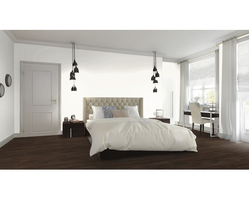 Schlafzimmer mit Bett, Nachttischen, Lampen und Arbeitsbereich am Fenster.