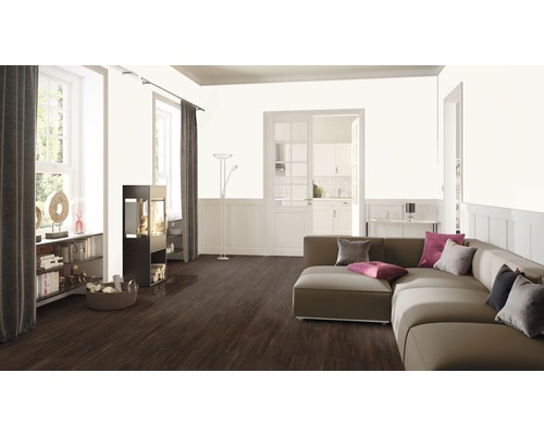 Wohnzimmer mit Sofa, Kaminofen, Bücherregal und Holzboden.