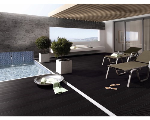 Terrasse avec piscine, mur carrelé, chaises longues et pots de fleurs