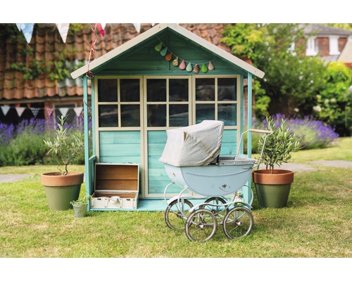 Scène avec une cabane pour enfants, une poussette et une décoration de jardin sur une pelouse