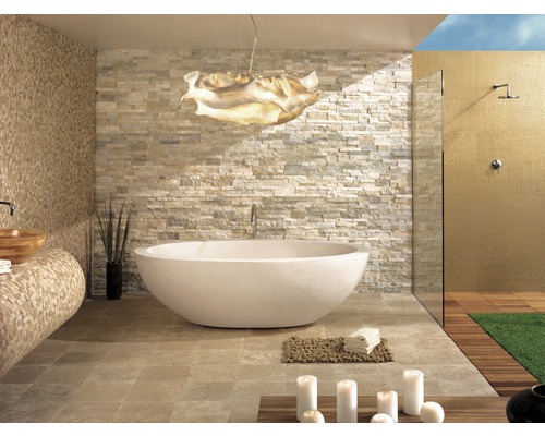 Salle de bains lumineuse avec baignoire îlot, mur en pierre et douche
