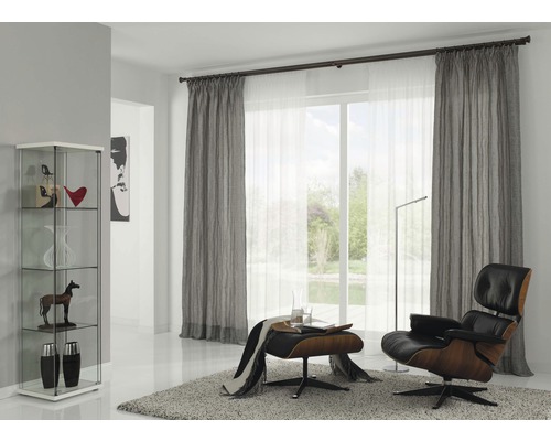 Salon avec rideaux, fauteuil et vitrine