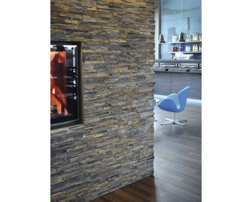 Wand mit Natursteinverblendung und Kamin im Wohnraum.