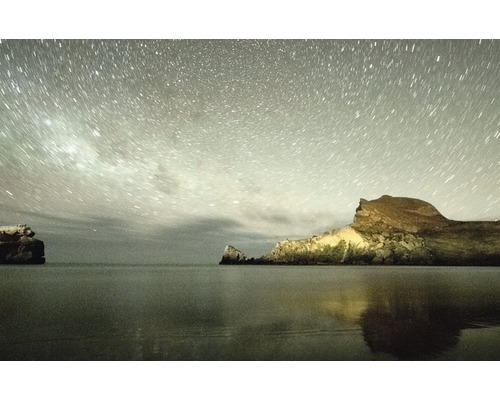 Ciel étoilé au-dessus des rochers au bord de la mer