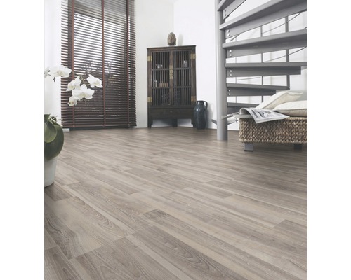 Pièce lumineuse avec sol stratifié, escalier en colimaçon et commode