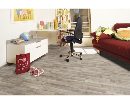 Chambre d''enfant avec plancher en bois clair, bureau et canapé rouge.