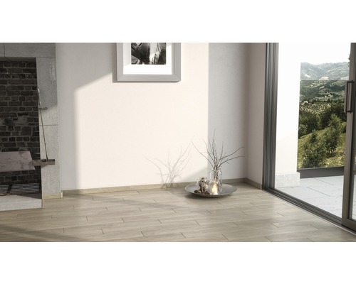 Heller Raum mit Kamin, Holzboden und Blick ins Grüne