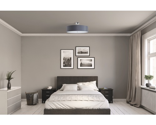 Chambre à coucher avec lit, tables de chevet, commode, plafonnier et décorations murales