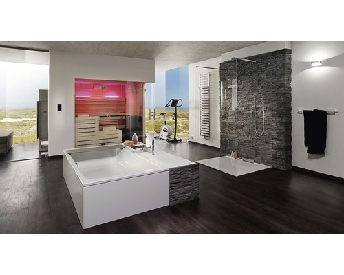 Salle de bains lumineuse avec baignoire, douche, sauna et vélo d''appartement