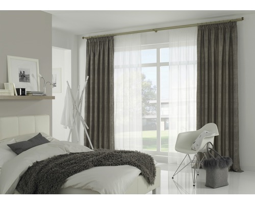 Chambre lumineuse avec lit, chaise, fenêtre et rideaux