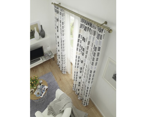 Salon avec fenêtre, rideaux à motifs géométriques et tringle à rideaux