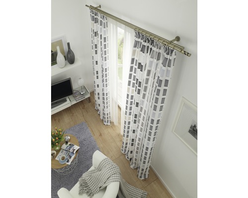 Salon avec rideaux à motifs géométriques et tringle à rideaux double