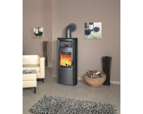 Salon avec poêle à bois, fauteuil, panier de bois et tapis