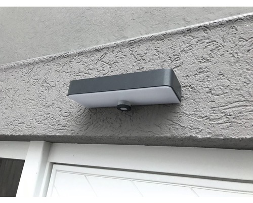Rechteckige Aussenleuchte mit Bewegungsmelder an einer Wand montiert