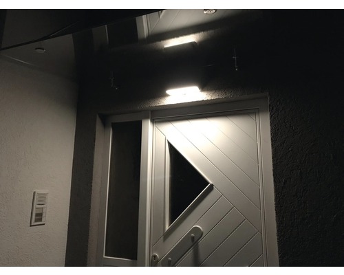 Beleuchteter Hauseingangsbereich mit Tür und Klingel