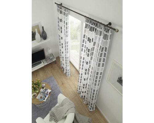 Wohnzimmer mit Fensterdekoration inklusive Vorhangschiene und gemusterten Vorhängen.