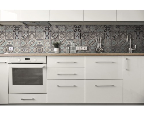 Cuisine claire avec armoires blanches, plan de travail en bois et carreaux au design patchwork