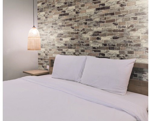 Wandbelag PVC Ceramics Tisa rot braun 67,5 x 400 cm Schlafzimmer mit Doppelbett, Nachttisch und Wand in Backsteinoptik