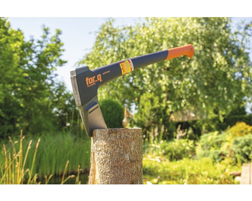 Spaltaxt auf einem Holzscheit im Garten mit For_q Logo.
