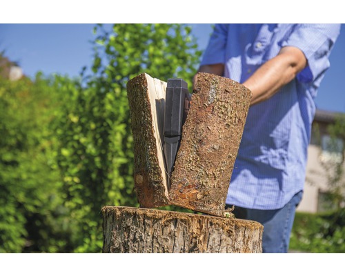 Eine Person spaltet Holz mit einem Holzspalter.