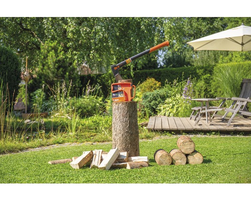 Gartenambiente mit einer Axt und Holzspaltern auf einem Holzstamm, umgeben von Holzstücken
