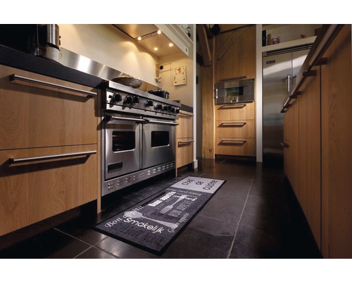 Scène de cuisine avec cuisinière en acier inoxydable, armoires de cuisine et tapis de cuisine