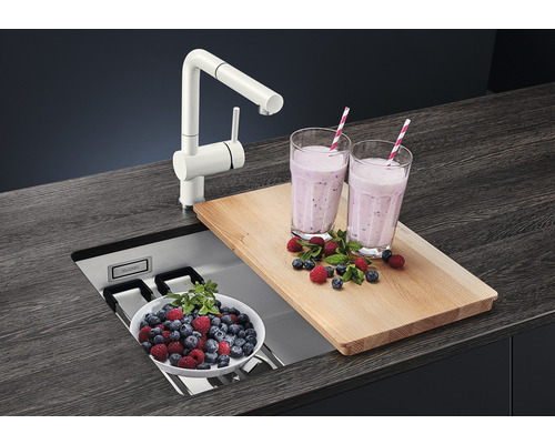 Évier de cuisine avec robinet, planche à découper et smoothies sur un plan de travail