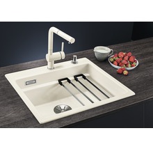 Évier de cuisine avec robinet, égouttoir et distributeur de savon sur un comptoir de cuisine avec des fraises et un pot de lait